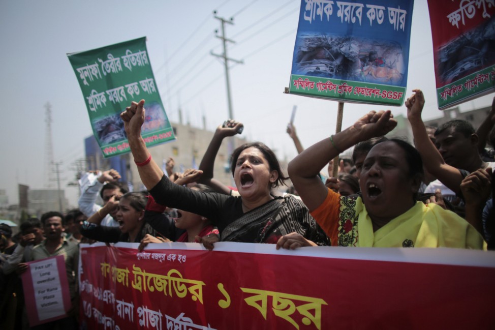 Relatives of victims killed in the collapse of Rana Plaza and activists shout slogans on the first year anniversary of the accident, as they gather in Savar