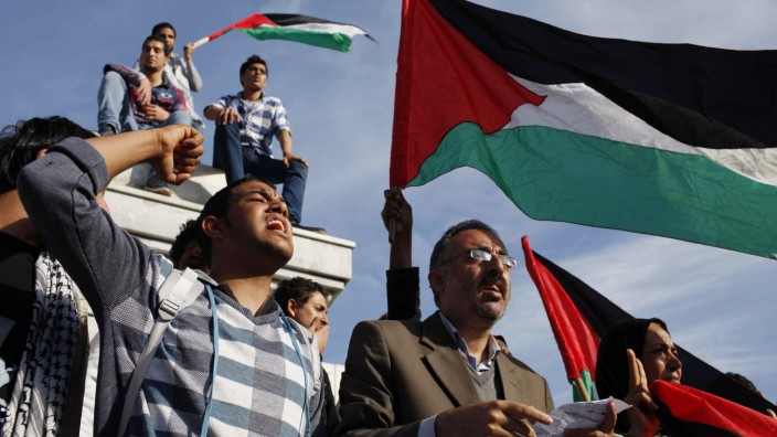 Palestinians wave national flags as they celebrate after an announcement of a reconciliation agreement in Gaza City