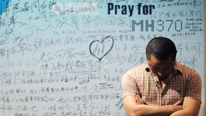 Sechs Monate ohne jede Spur von Flug MH370: Beten für MH370: Ein Angehöriger vor einer Gedenktafel für die verschollenen Passagiere des Malaysian Airlines-Fluges.
