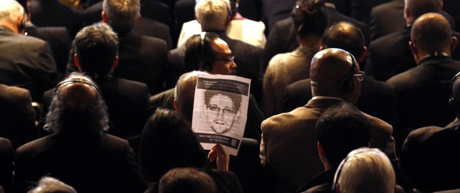An attendee holds a sign showing Edward Snowden during the NETmundial: Global Multistakeholder Meeting on the Future of Internet Governance in Sao Paulo