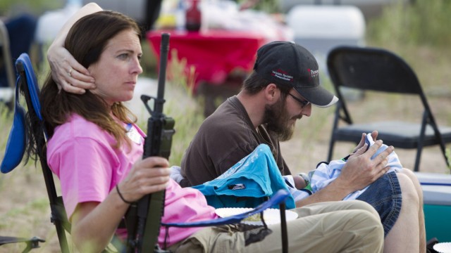 Shelton interacts with his son as his mother holds his rifle during a Bundy family 'Patriot Party' near Bunkerville, Nevada