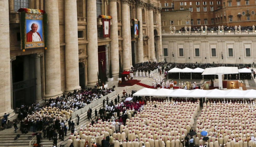 Tapestry portraits of Pope John XXIII and John Paul II are seen in a general view of the mass ahead of the canonisation ceremony in St. Peter's Square at the Vatican