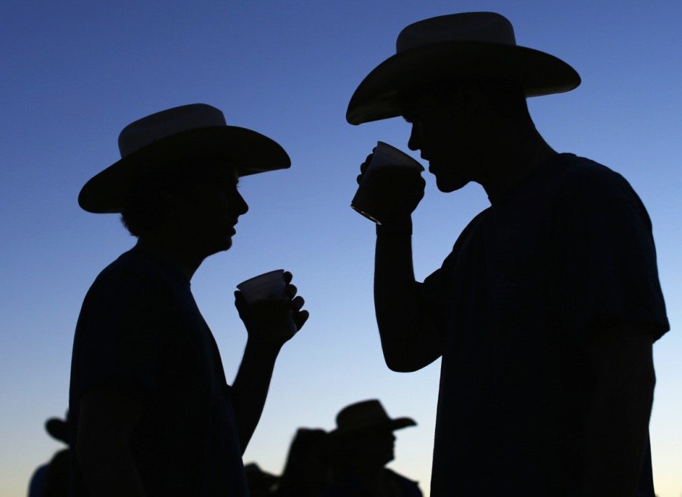 Country music fans drink beer as night falls during final day of Stagecoach country music festival in Indio