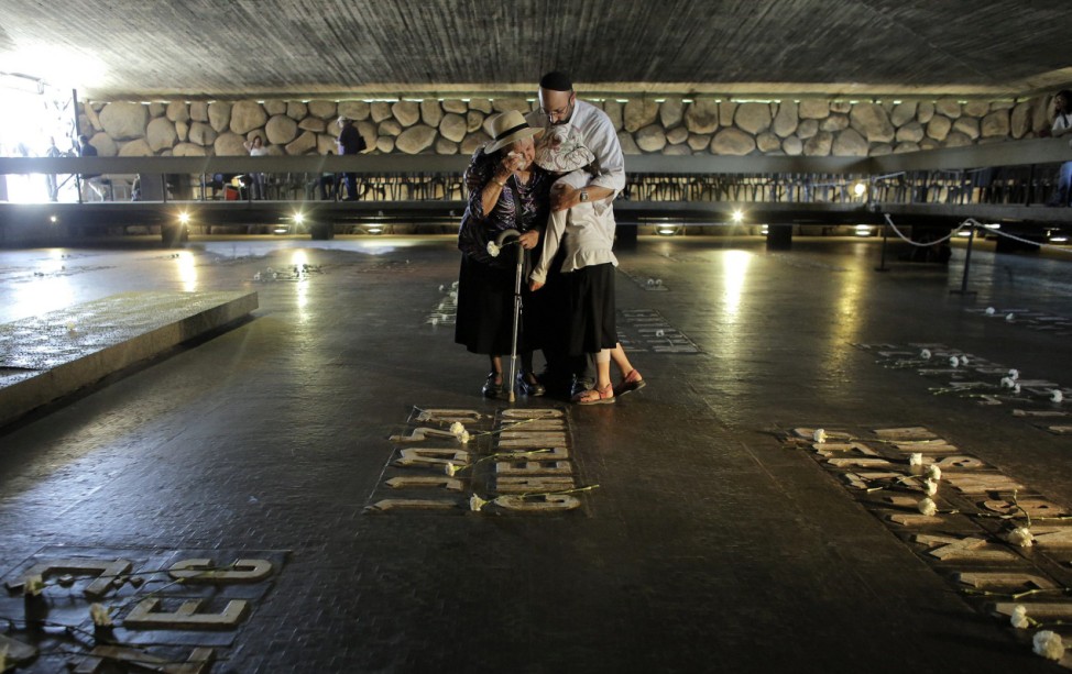 Israeli woman is comforted as she cries in the Hall of Remembrance during a ceremony in Jerusalem
