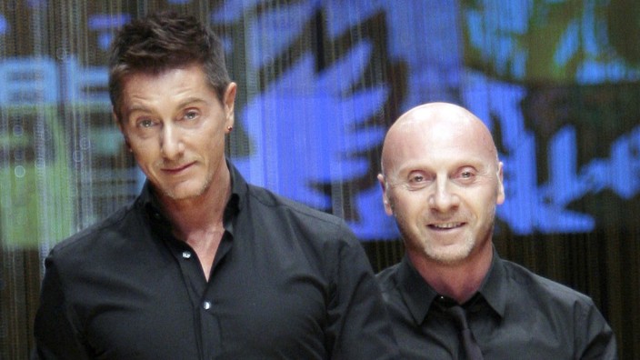 File photo of designers Dolce and Gabbana acknowledging the applause at the end of their D&G's Spring/Summer 2008 men's collection show in Milan