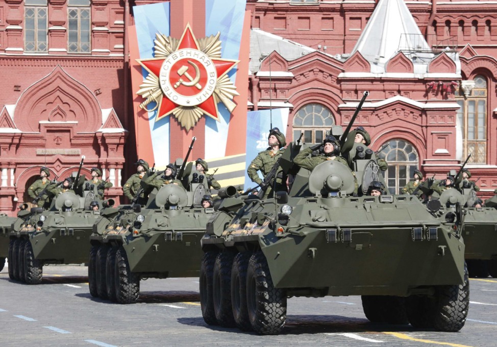 Russian servicemen aboard armoured personnel carriers salute during the Victory Day parade in Moscow's Red Square
