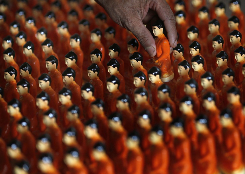 A man packs statues of Buddha at a workshop ahead of Vesak Day celebrations in Colombo