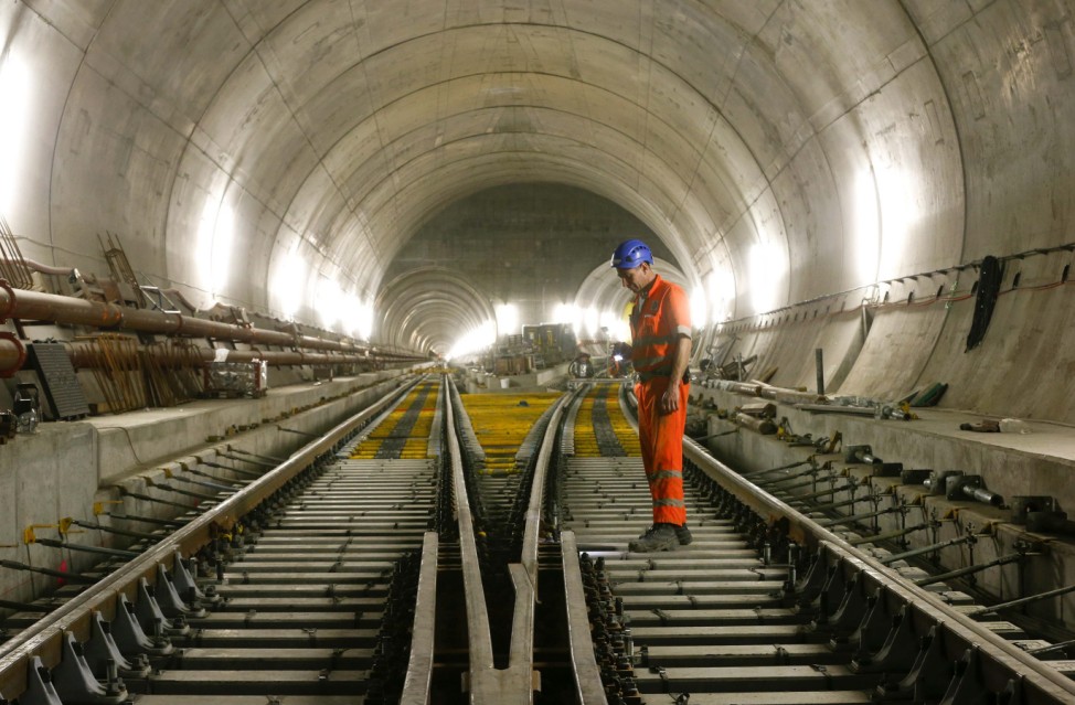 A worker checks the railway tracks during installation works in the NEAT Gotthard Base tunnel near Faido