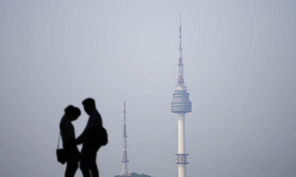 A couple is silhouetted against the backdrop of N Seoul Tower, commonly known as Namsan Tower, in Seoul
