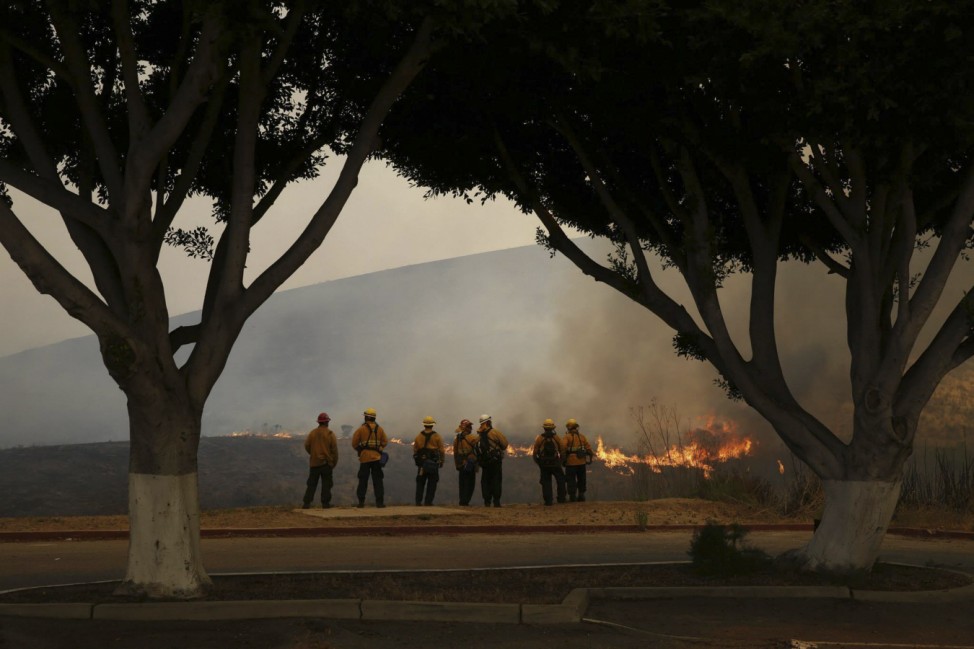 Firefighters watch the Las Pulgas Fire at Camp Pendleton, California