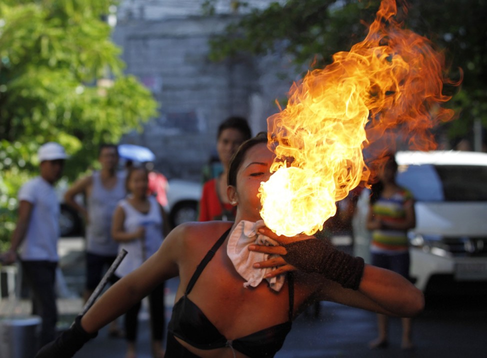 A street performer breathes fire on the eve of the feast day of the town's patron Saint Rita in Paranaque city, metro Manila