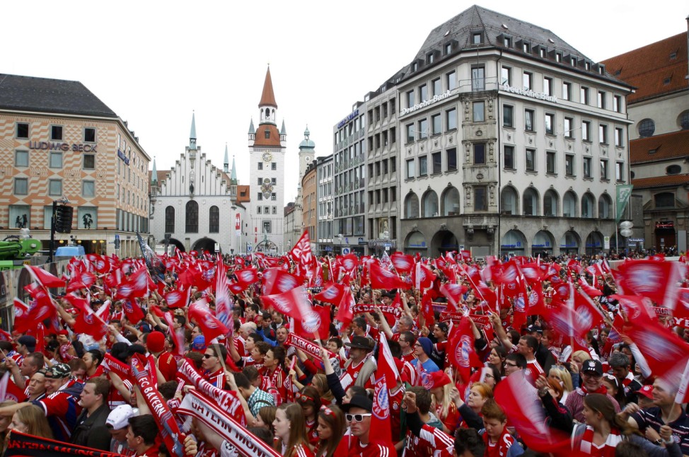Bayern Munich's supporters wave flags as they wait for the arrival of their team in central Munich