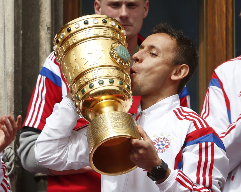 Bayern Munich's Rafinha kisses the German Cup trophy at the balcony of the town hall during celebrations after their German Cup final against Borussia Dortmund, in central Munich
