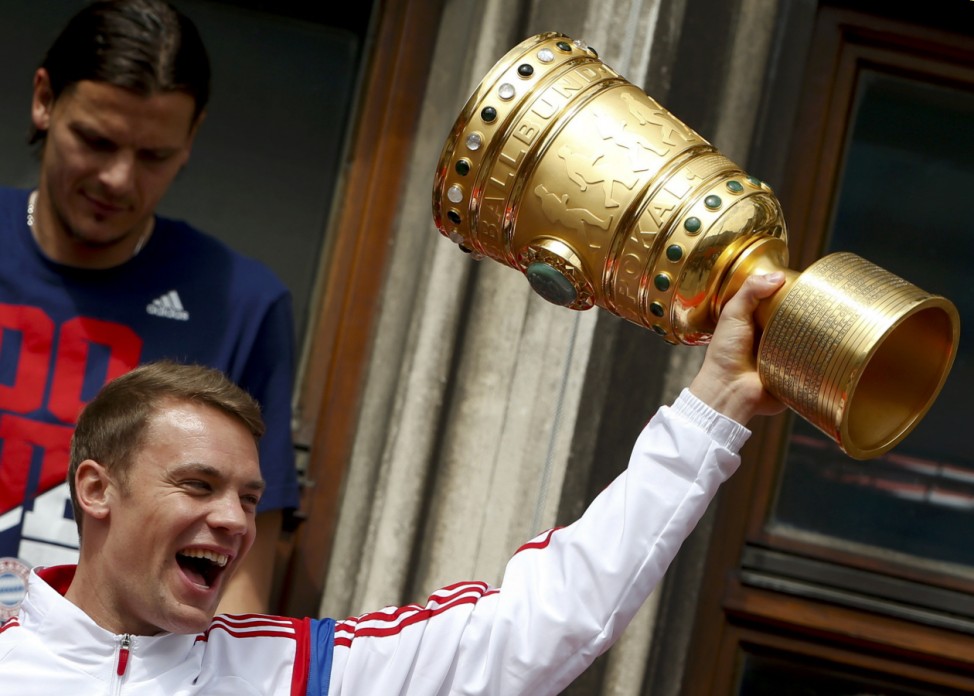 Bayern Munich's Neuer lifts up the German Cup trophy at the balcony of the town hall during celebrations after their German Cup final against Borussia Dortmund, in central Munich