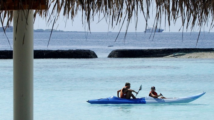Geschäft mit dem Familienurlaub: Kinder paddeln im Urlaub vor Kurumba Island, Malediven.