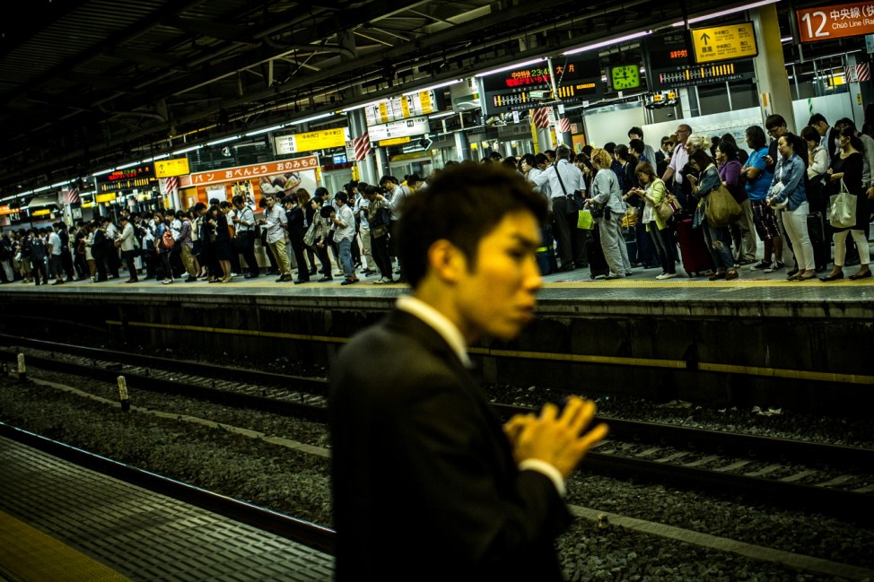 Commuters Wait For Trains at Shinjuku Station