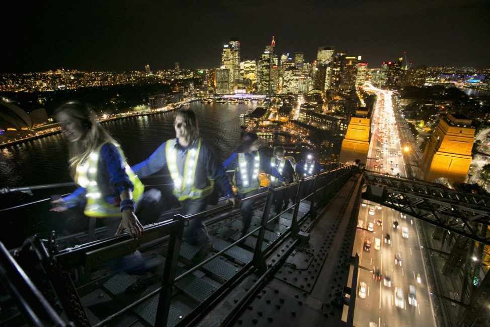 Participants in the Sydney Harbour BridgeClimb wear lighted vests as they climb the bridge high above the city traffic at night, during a preview of the Vivid Sydney light and music festival