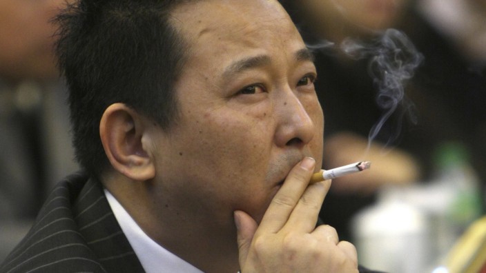 File photo shows Liu Han smoking a cigarette during a conference in Mianyang