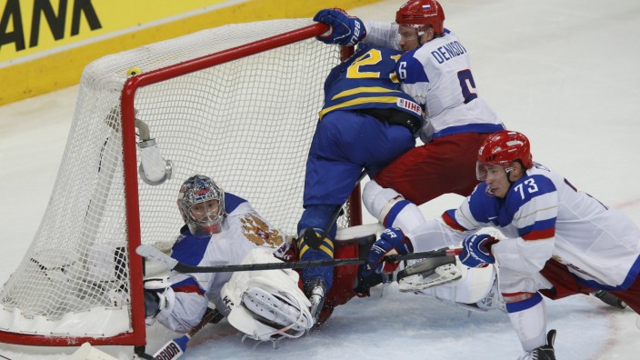 Russia's goalie Bobrovski saves as team mate Denisov checks Sweden's Ericsson into the net during their men's ice hockey World Championship semi-final game at Minsk Arena in Minsk