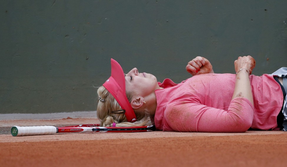 Sabine Lisicki of Germany lies on the court after falling during her women's singles match against compatriot Mona Barthel at the French Open tennis tournament at the Roland Garros stadium in Paris