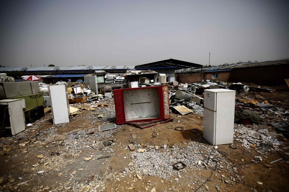 Broken fridges are seen in the yard of a recycling workers' tenement house in Dongxiaokou village in Beijing