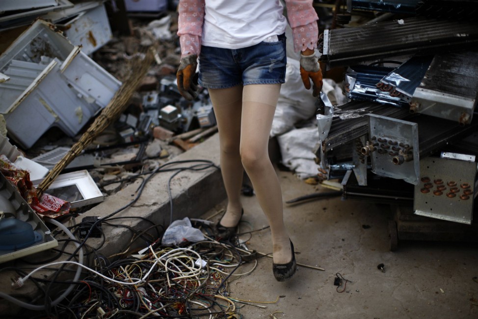 A recycling worker stands in the yard of a tenement house at Dongxiaokou village in Beijing