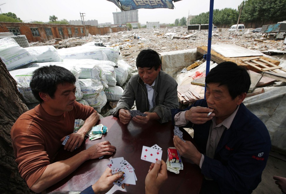 Recycling workers play poker in Dongxiaokou village in Beijing