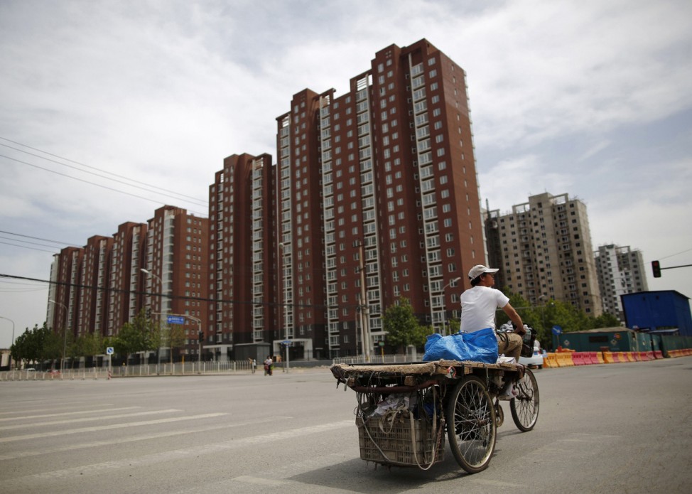 A garbage collector rides his tricycle as he looks for recyclable items on the streets of Beijing