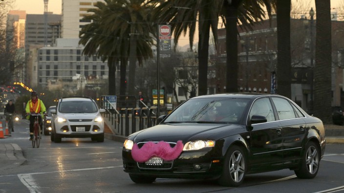Taxi-Streit in den USA: Dieses leuchtende Symbol fällt auf: Der rosa Schnurrbart steht für das Fahrdienst-Netzwerk Lyft.