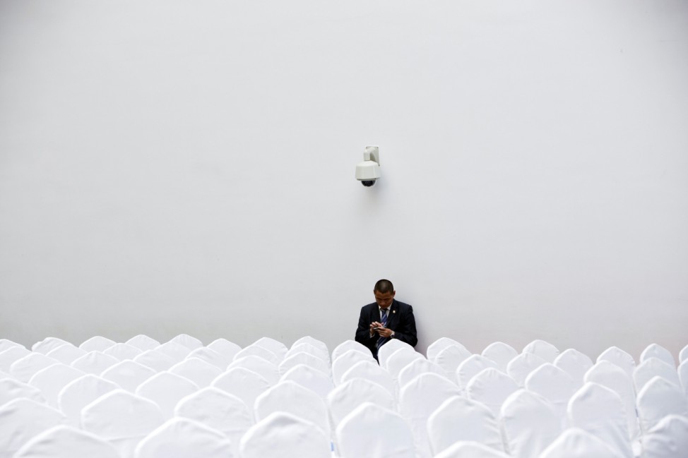 A security personnel checks his mobile phone before a meeting attended by Italy's Prime Minister Matteo Renzi, at the Shanghai Italy Center in Shanghai