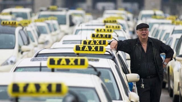 A taxi driver listens to speeches by his colleagues, during an Europe-wide protest of licensed taxi drivers against taxi hailing apps that are feared to flush unregulated private drivers into the market, in Berlin