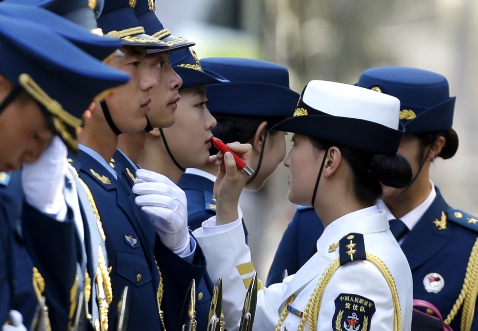 Female honour guard has lipstick applied as they prepare for an official welcoming ceremony for Italy's PM Renzi outside the Great Hall of the People in Beijing