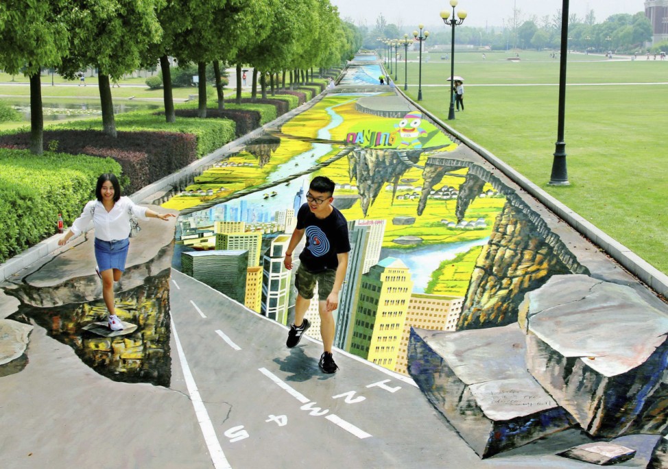 College students pose for pictures with a 3D painting along a street at campus in Nanjing