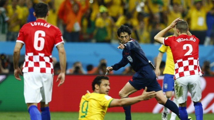 Referee Yuichi Nishimura of Japan gestures for a penalty during the 2014 World Cup opening match between Brazil and Croatia at the Corinthians arena in Sao Paulo