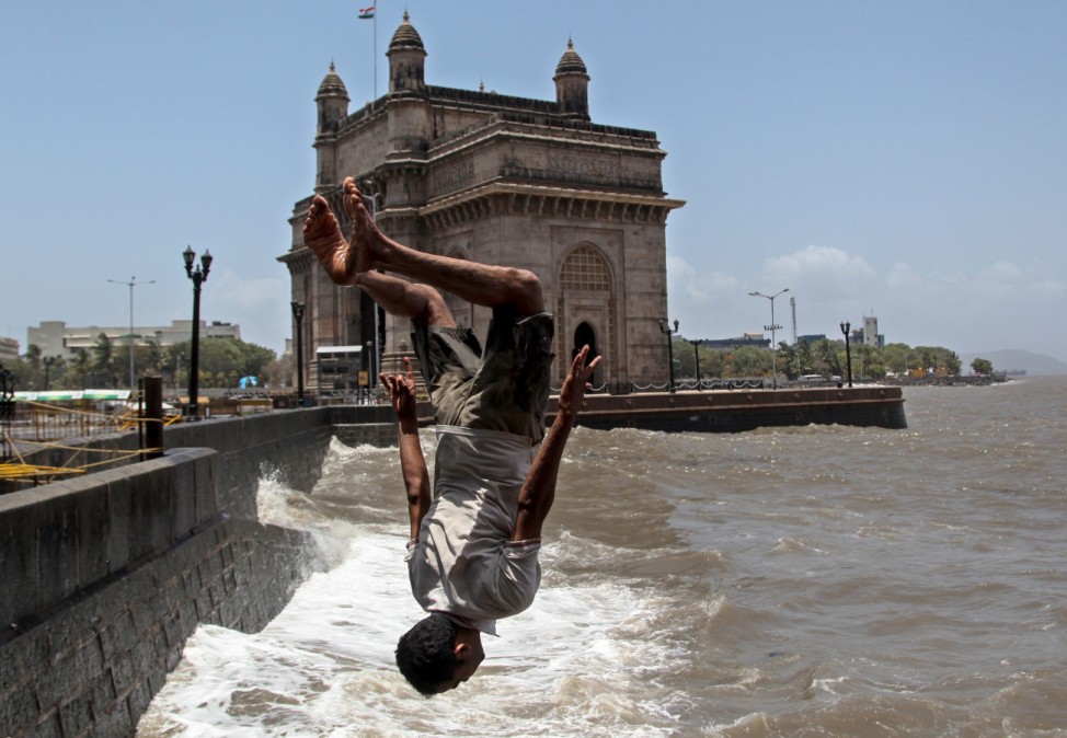 An Indian man jumps into the Arabian sea near the Gateway of Indi