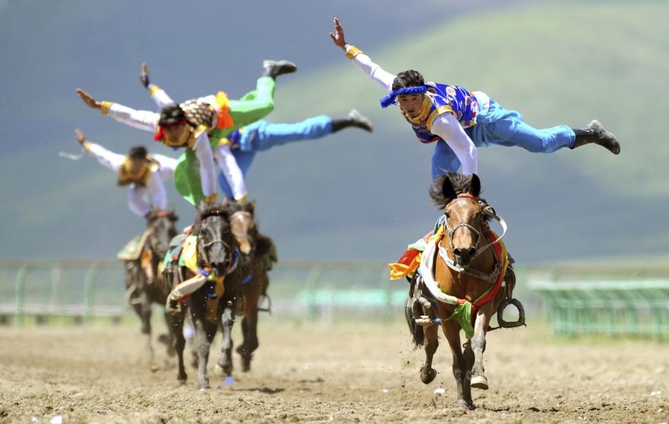 Tibetan participants perform on horses during a traditional equestrian competition in Aba Tibetan and Qiang Autonomous Prefecture