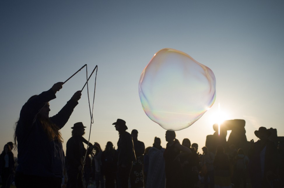 A reveller creates bubbles as she celebrates the summer solstice on Salisbury Plain in southern England