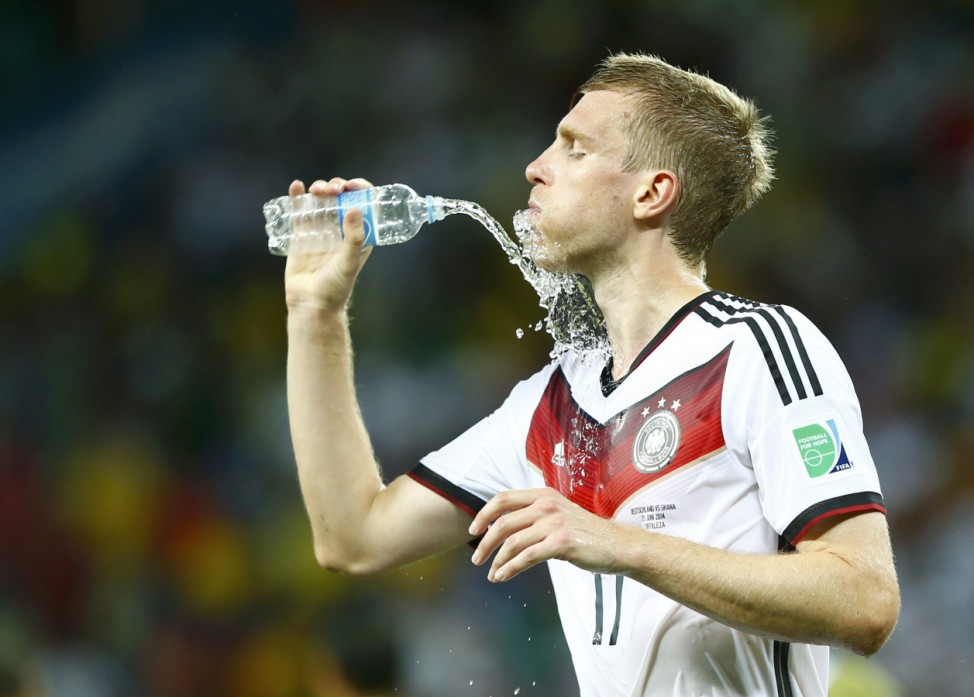 Germany's Per Mertesacker refreshes himself after the 2014 World Cup Group G soccer match between Germany and Ghana at the Castelao arena