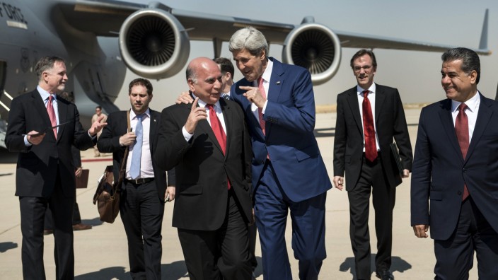 U.S. Secretary of State Kerry talks with Hussein, chief of staff at the presidency of the Kurdistan Regional Government, while accompanied by Kurdish regional foreign relations minister Bakir and other officials, at Arbil International Airport