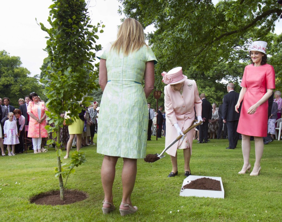 Britain's Queen Elizabeth plants a tree during a garden party at Hillsborough Castle