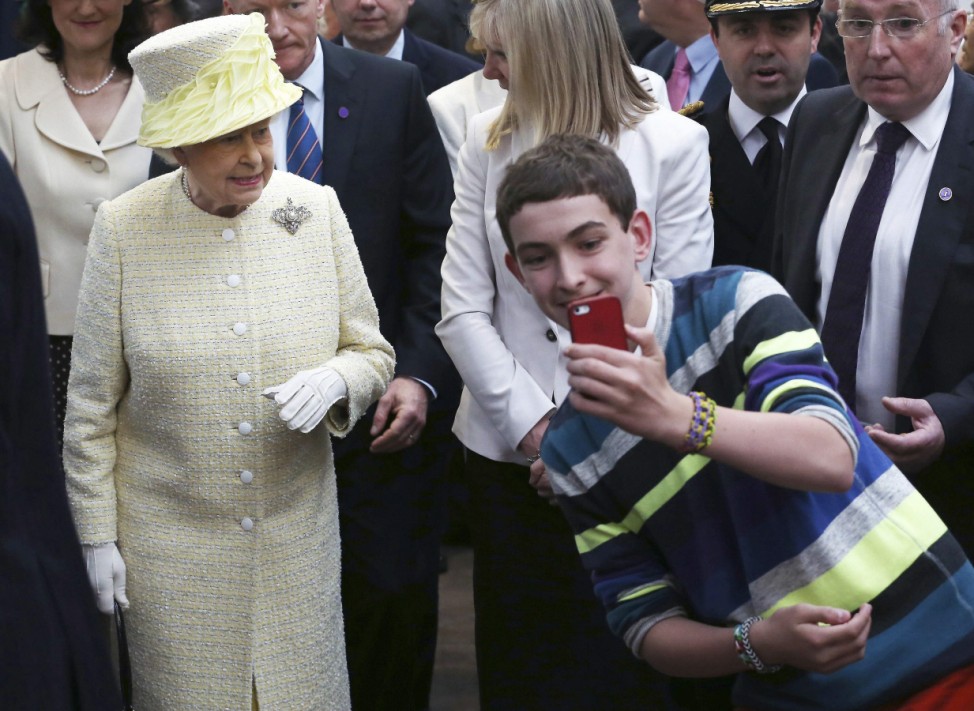 A local youth takes a selfie in front of Britain's Queen Elizabeth in St George's indoor market in Belfast