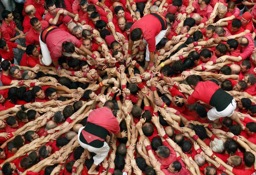 Castellers Colla Joves Xiquets de Valls start to form a human tower called 'castells' during the Sant Joan festival at Plaza del Blat square in Valls