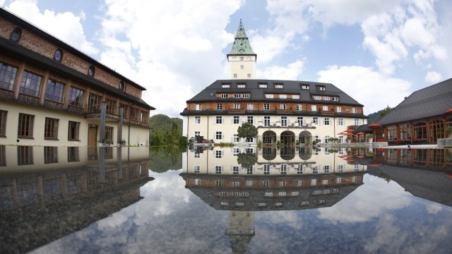 Hotel castle Elmau is reflected in fountain in Kruen