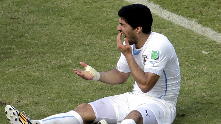 Uruguays Luis Suárez: Luis Suárez hält sich nach seiner Beißattacke auf dem Rasen die Zähne.