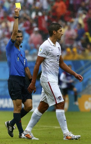 Gonzalez of the U.S. receives a yellow card from referee Irmatov of Uzbekistan during their 2014 World Cup Group G soccer match against Germany at the Pernambuco arena in Recife