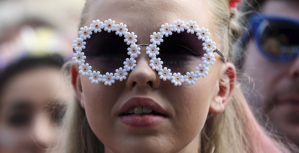 A festival goer watches the English National Ballet perform on the Pyramid stage at Worthy Farm in Somerset, during the Glastonbury Festival