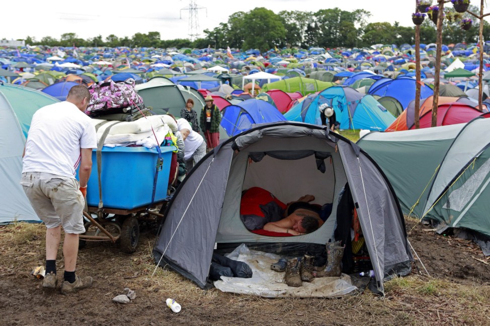 A festival goer sleeps in a tent near the Pyramid stage at Worthy Farm in Somerset, during the Glastonbury Festival