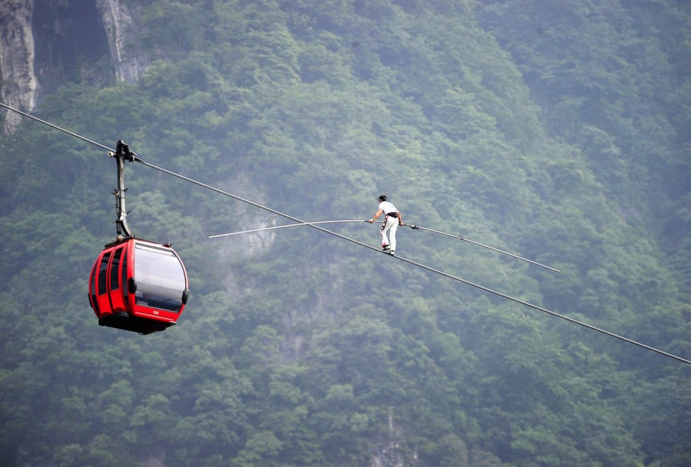 Swiss acrobat Freddy Nock balances on cableway over mountain at Tianmen Mountain National Park in Zhangjiajie