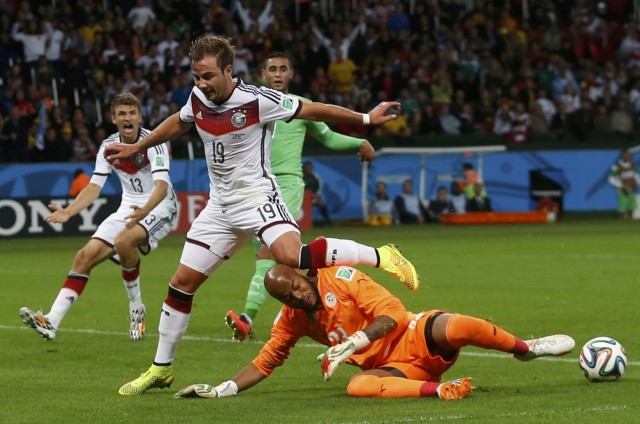 Algeria's goalkeeper Mbolhi saves the ball beside Germany's Goetze and Mueller during their 2014 World Cup round of 16 game at the Beira Rio stadium in Porto Alegre