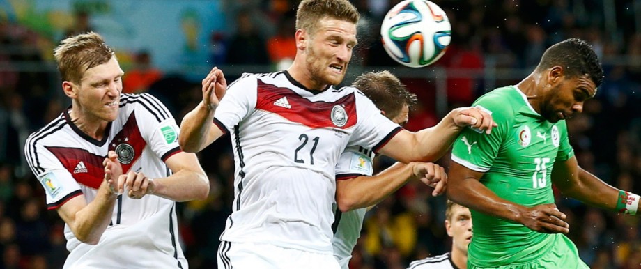 Germany's Mertesacker and Mustafi jump for the ball with Algeria's Soudani during their 2014 World Cup round of 16 game at the Beira Rio stadium in Porto Alegre